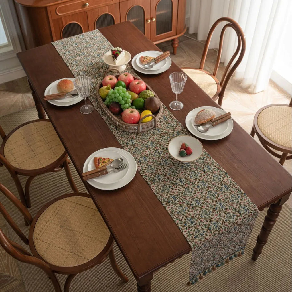 Dark blue striped floral jacquard table runner laid flat on a wooden dining table.