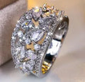 Women's round hollow fashion ring in gold or platinum plating with a blue or white cubic zirconia stone.