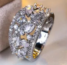Women's round hollow fashion ring in gold or platinum plating with a blue or white cubic zirconia stone.