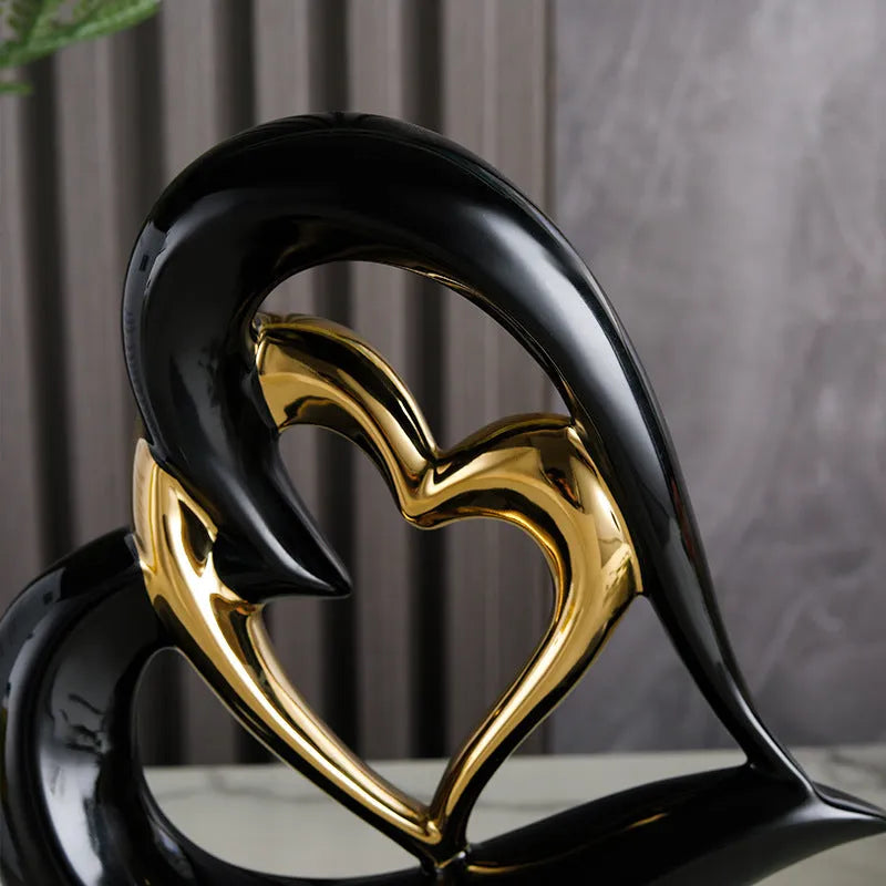 Modern geometric heart-shaped porcelain ornament in a metallic finish displayed on a cabinet.