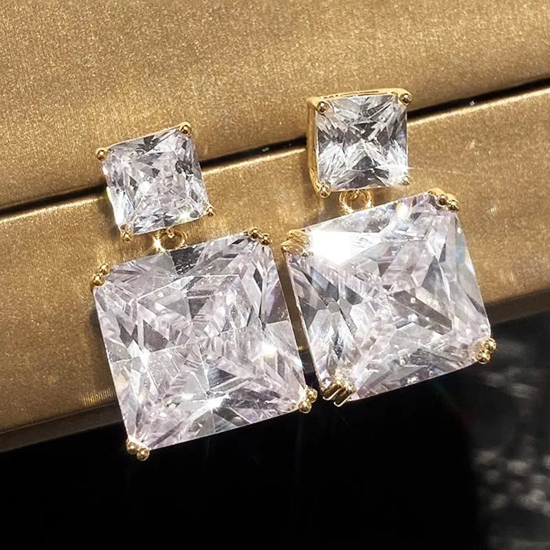 A pair of women's copper geometric square stud earrings in white gold or gold colour finish.