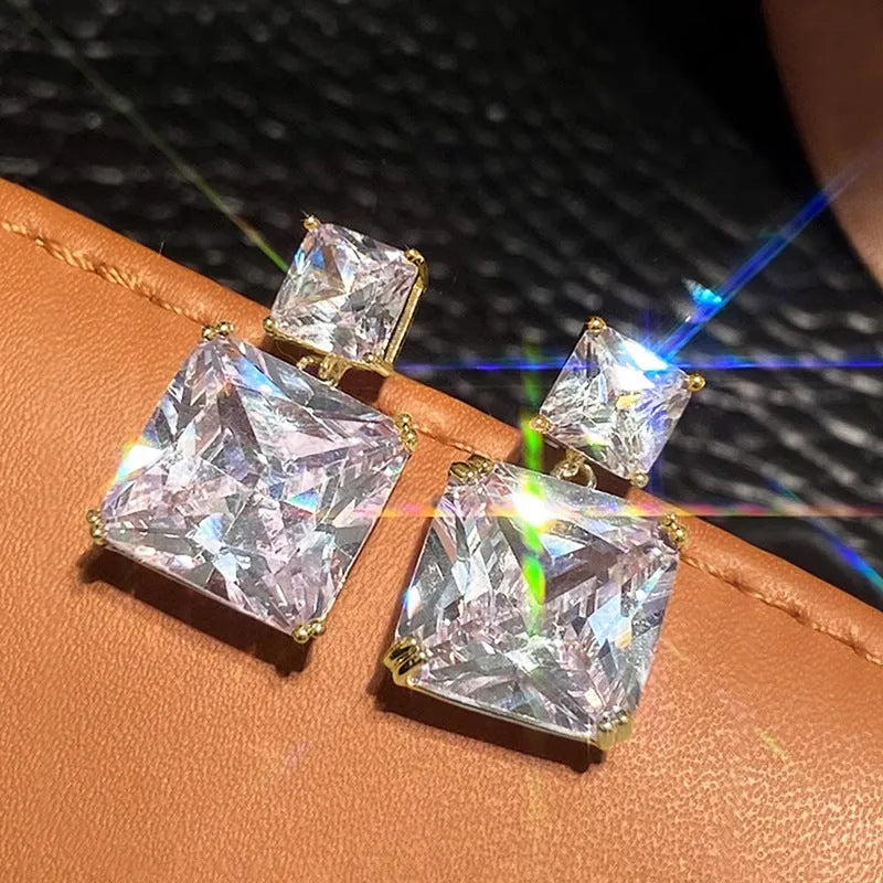 A pair of women's copper geometric square stud earrings in white gold or gold colour finish.