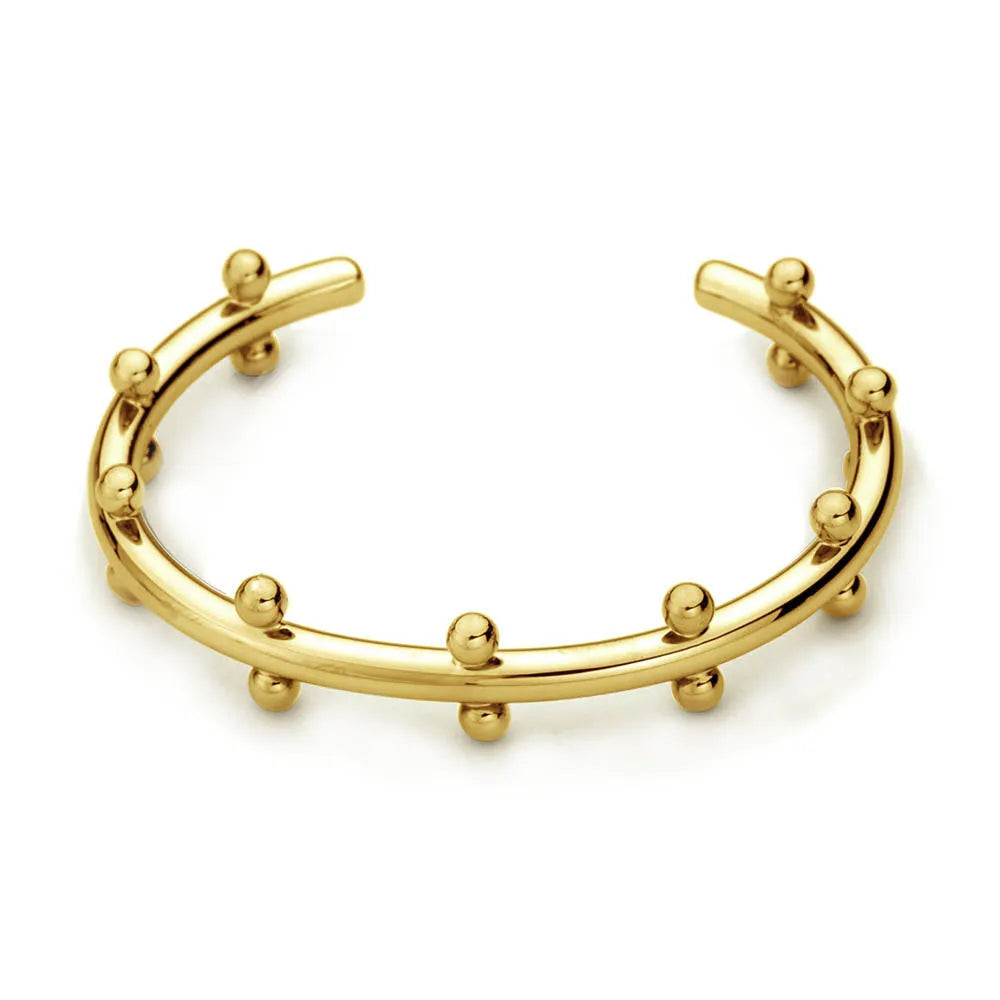 C-shaped stainless steel alloy bracelet with textured rivet-shaped beads on a wrist.