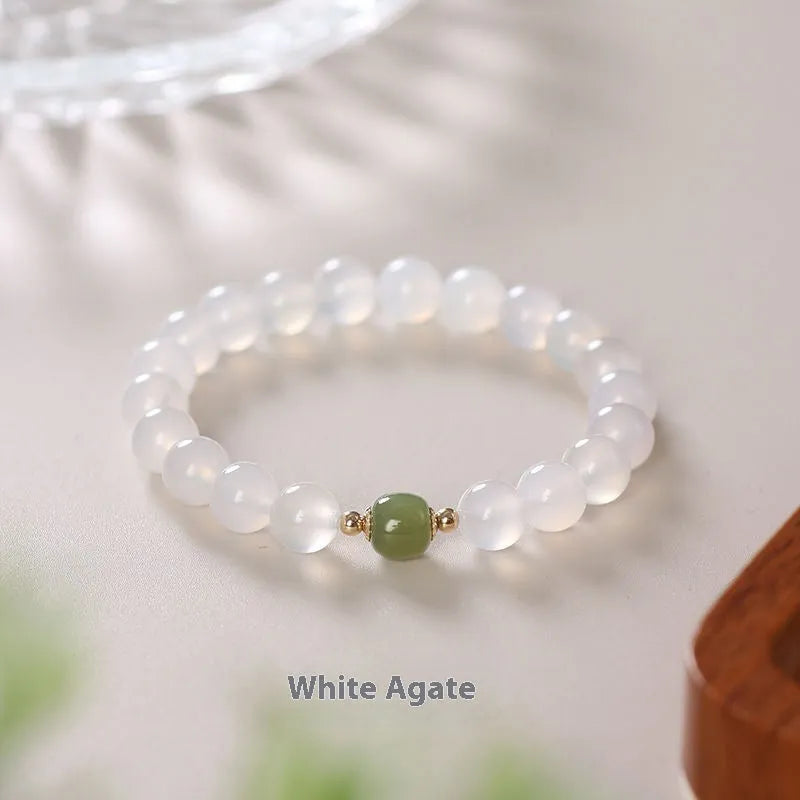 Handmade white agate and Hetian jade bracelet with red cinnabar inlay and a text charm.
