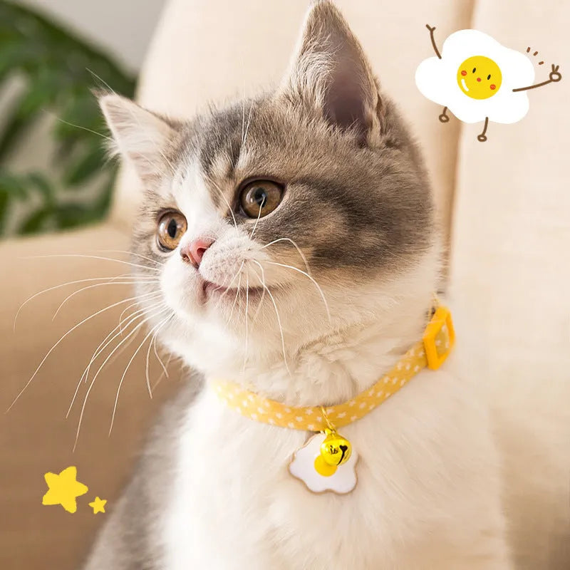 Green adjustable cat collar with a bow tie and bell pendant on a white background.