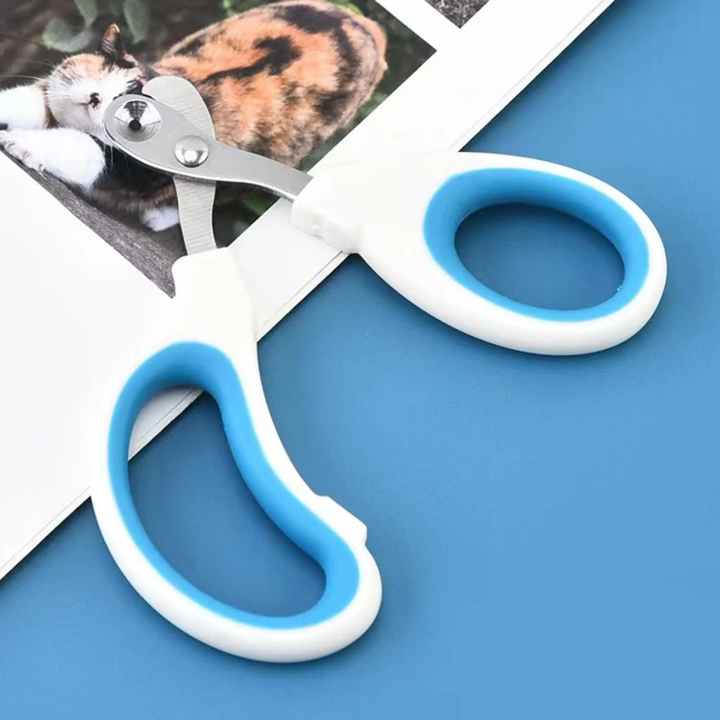 Blue cat nail clippers with circular cutting hole and cushioned handle on a white surface.