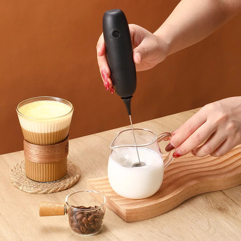 Handheld electric milk frother and blender in modern simple design, shown in black and white colour options.