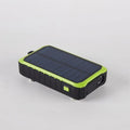 Orange or green hand crank solar power bank with solar panel, dual USB ports, and LED light.