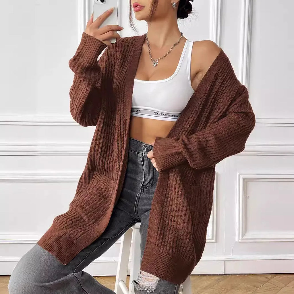 Women's dark green double pocket acrylic cardigan with long sleeves on a hanger.