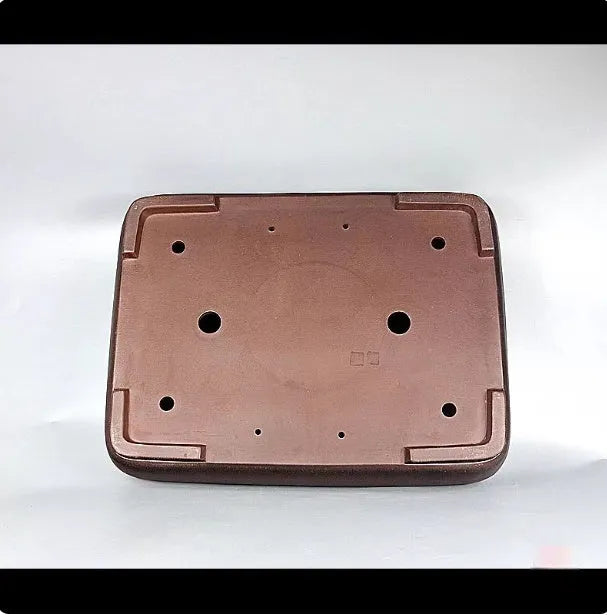 Handmade antique rectangular purple clay flower pot on a wooden surface.