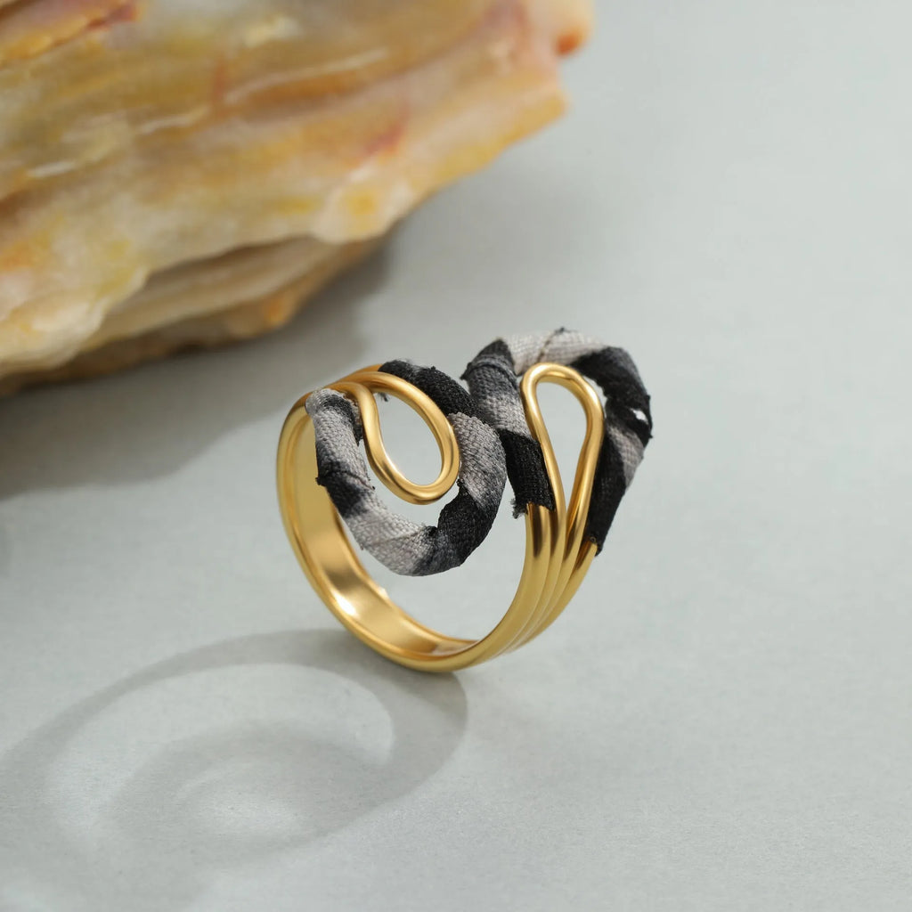 Leopard print geometric open mouth stainless steel ring on a grey background.