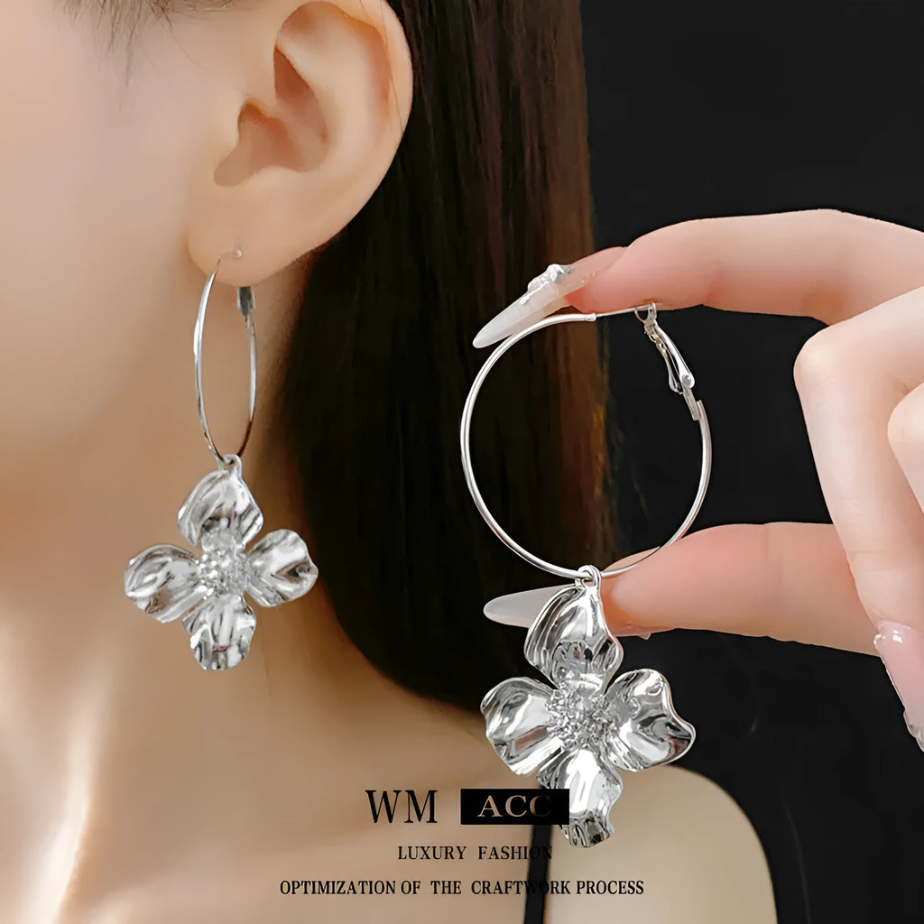 A pair of silver needle metal flower earrings with a geometric design in a gold or silver colour.