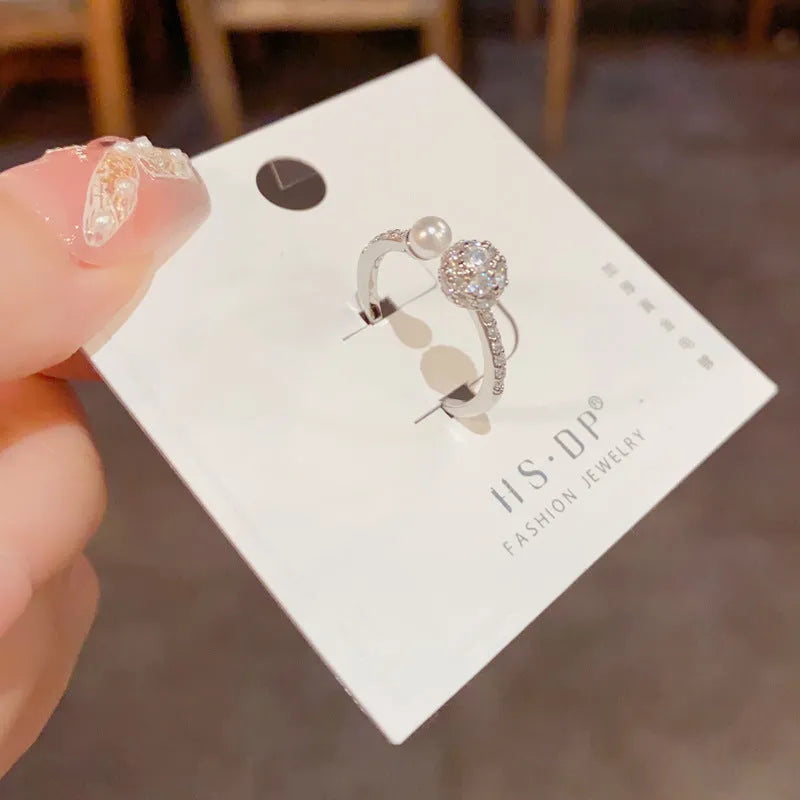 Open-end women's ring with round zircon detailing and pearl elements in gold or silver plated finish