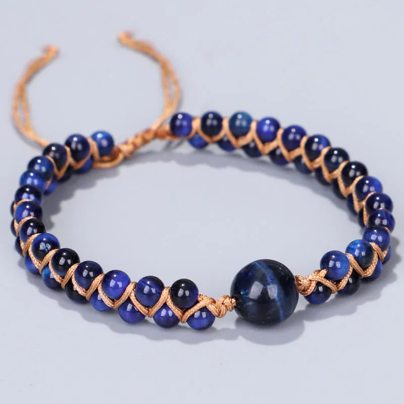 Hand-woven geometric pull bracelet made from blue tigereye stone beads on a wrist.
