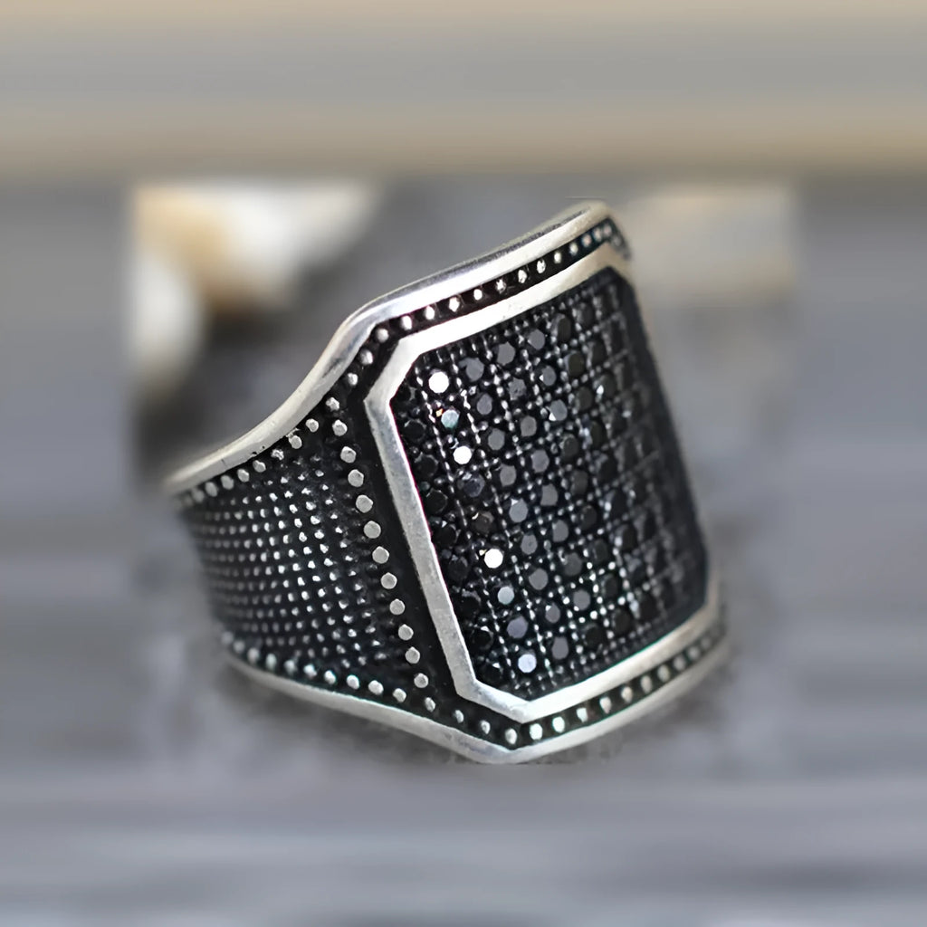 Black alloy ring with copper detailing and zircon accents shown in unisex design