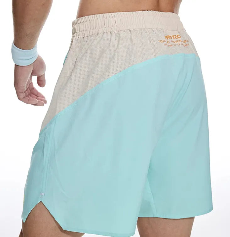 Men's loose grey workout shorts with elastic lace-up waistband on a hanger.
