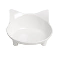 Set of four white shallow melamine pet bowls with black non-slip rubber bases on a table.