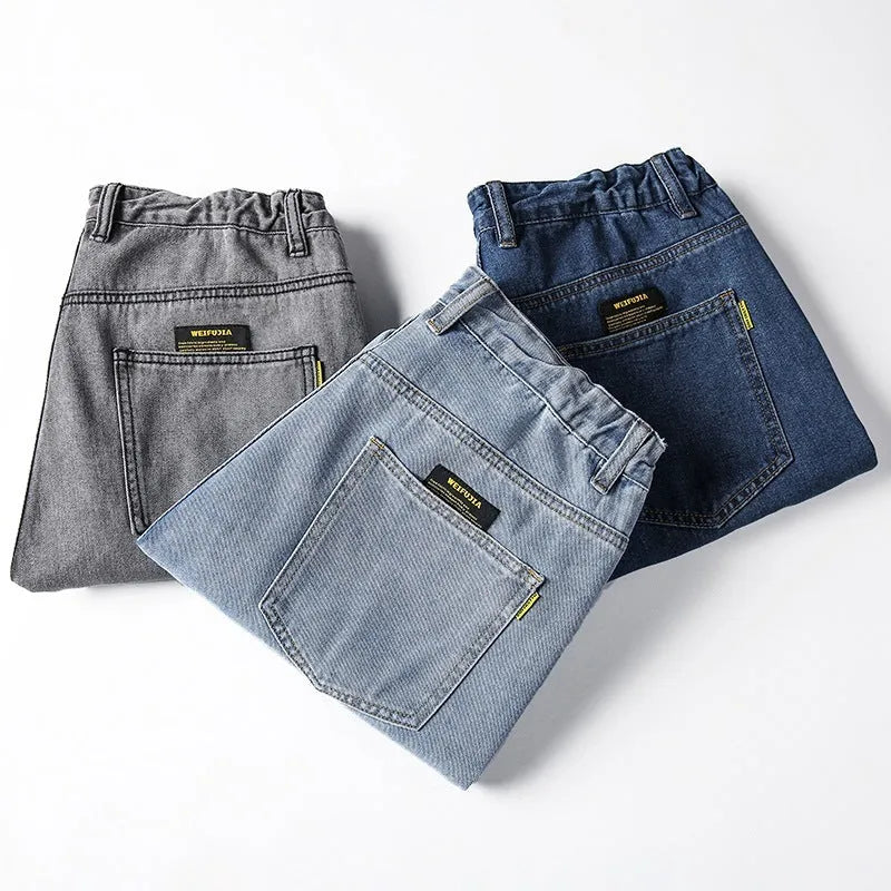 Men's loose straight blue jeans on hanger showing mid-waist design and straight leg cut