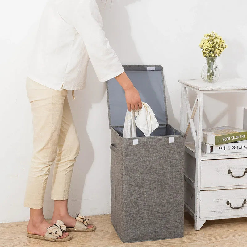 Foldable cotton linen storage basket in grey, shown in a modern room holding clothes and books.