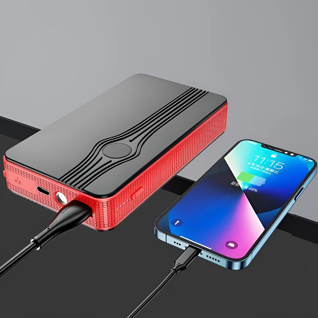 Red K4-E automobile emergency starting power supply unit with a data cable on a surface.