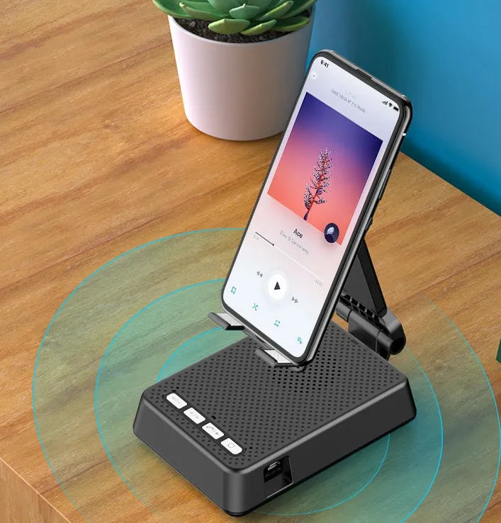 Black mobile phone broadcast stand with integrated Bluetooth speaker and microphone on a desk.