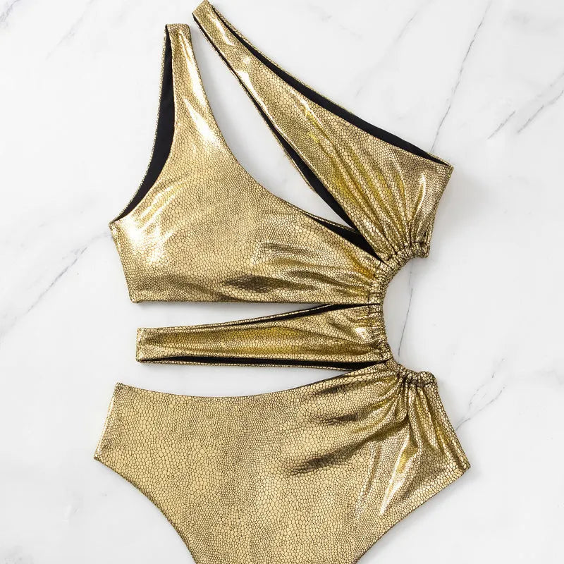 Gold backless one-piece swimsuit for women on a white background.