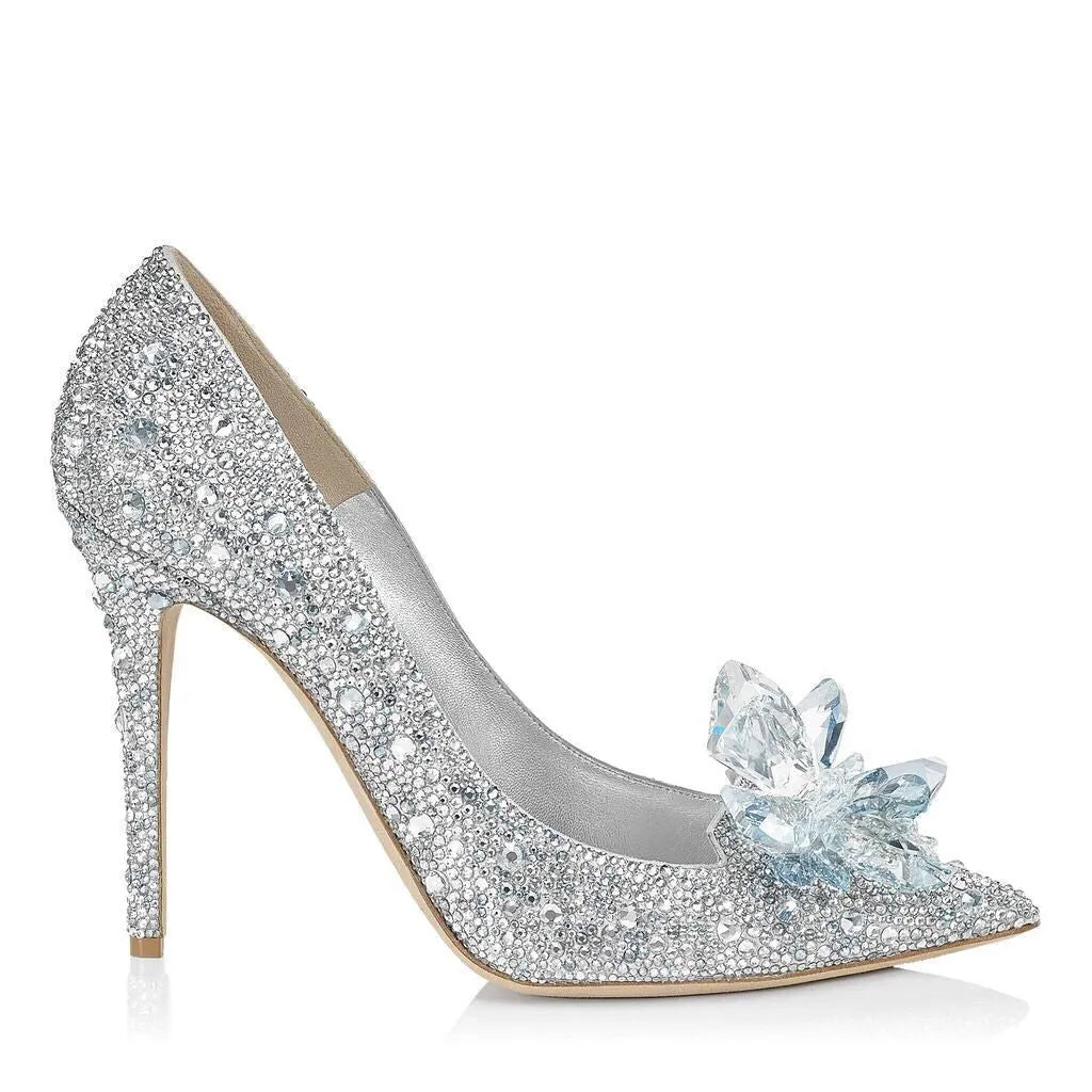Women's gold stiletto high heels with rhinestone and bow decorations on pointed toe.