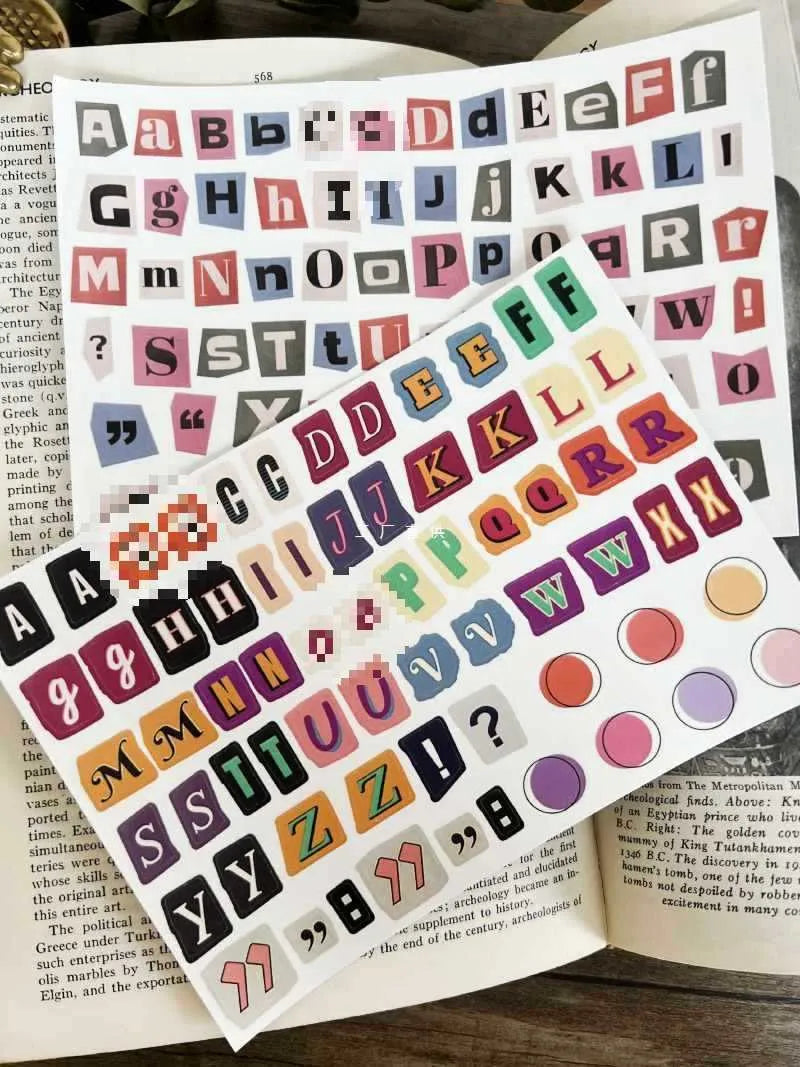 Set of printed cute-style stickers showing English letters, numbers, and weekday words on a sheet.