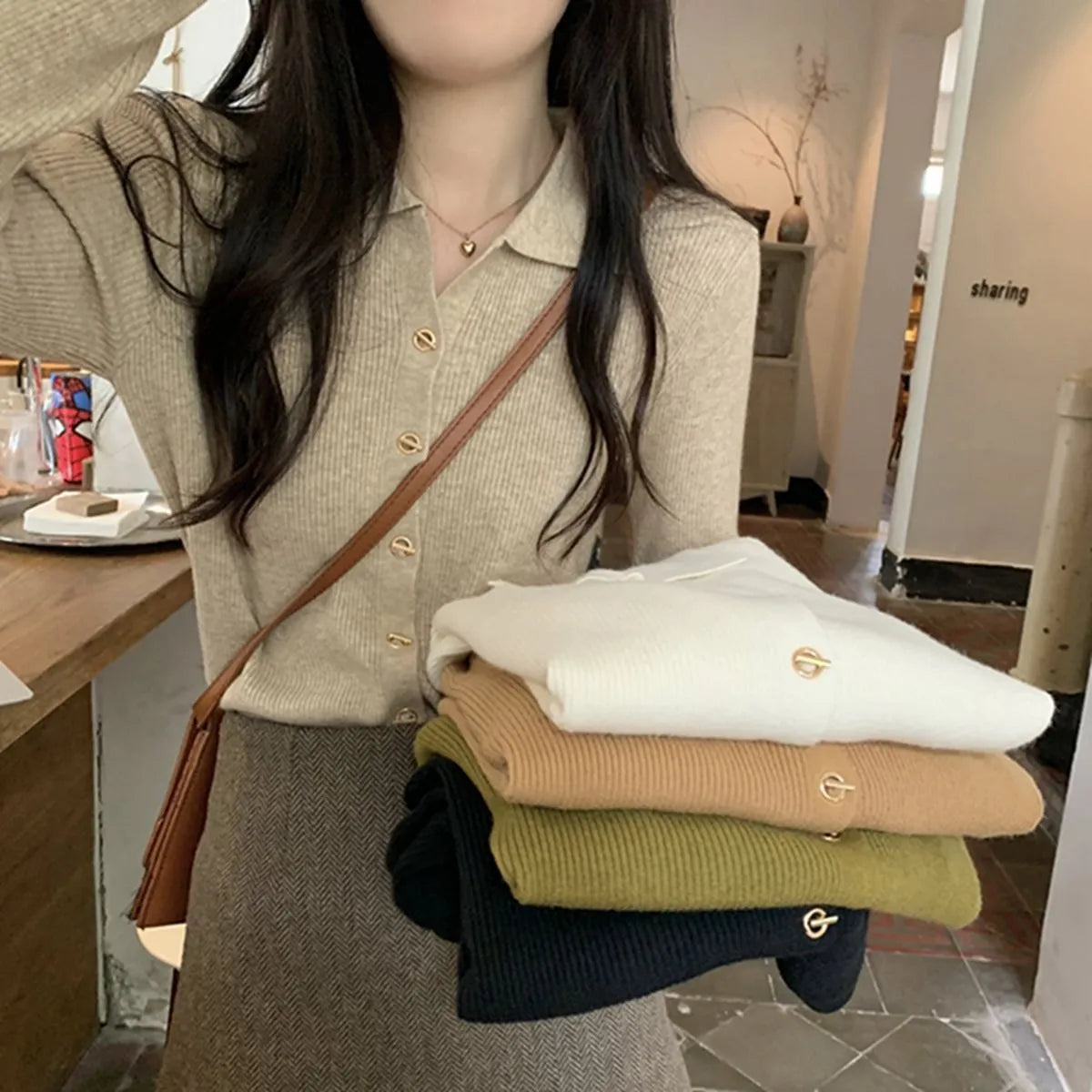 Beige long-sleeved viscose knitted cardigan hanging on a hanger, loose fit