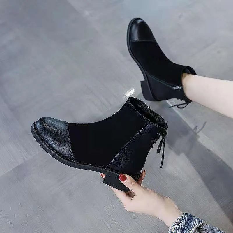 Black women's knee-high Martin boots with side zip and round toe on a rubber sole.