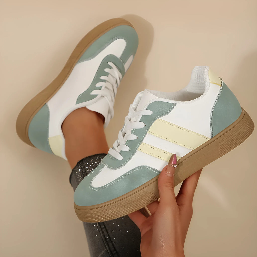 Green women's retro sports pumps with white cross straps and a round toe.