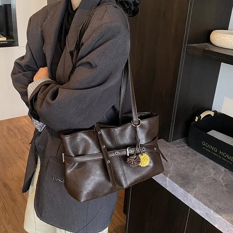 One-shoulder underarm tote bag in PU with polyester lining, zip coin pocket, and splicing detail.