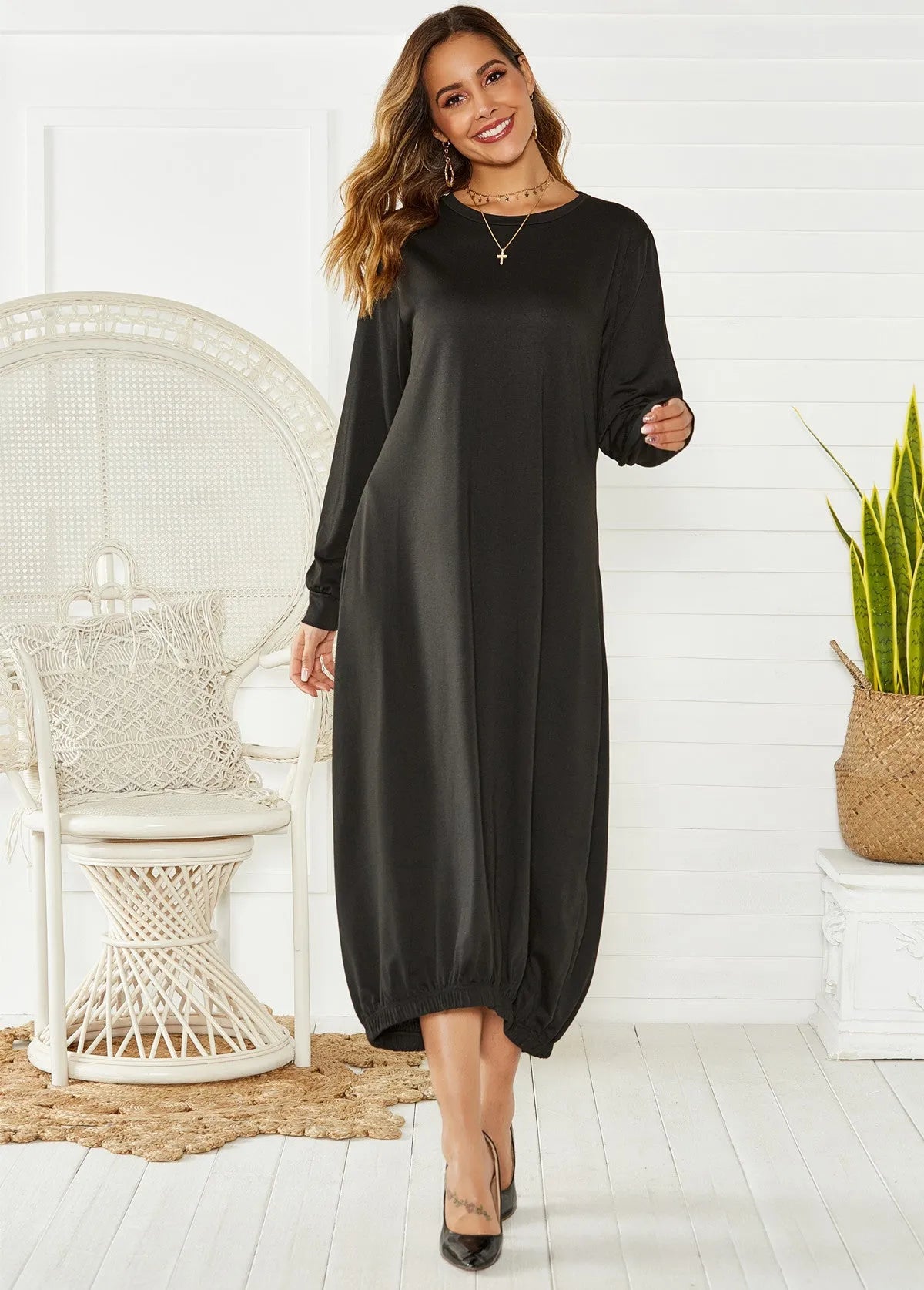 A loose-fitting, long black lantern dress with a lace-up detail at the crew neck, made from knitted polyester fabric.