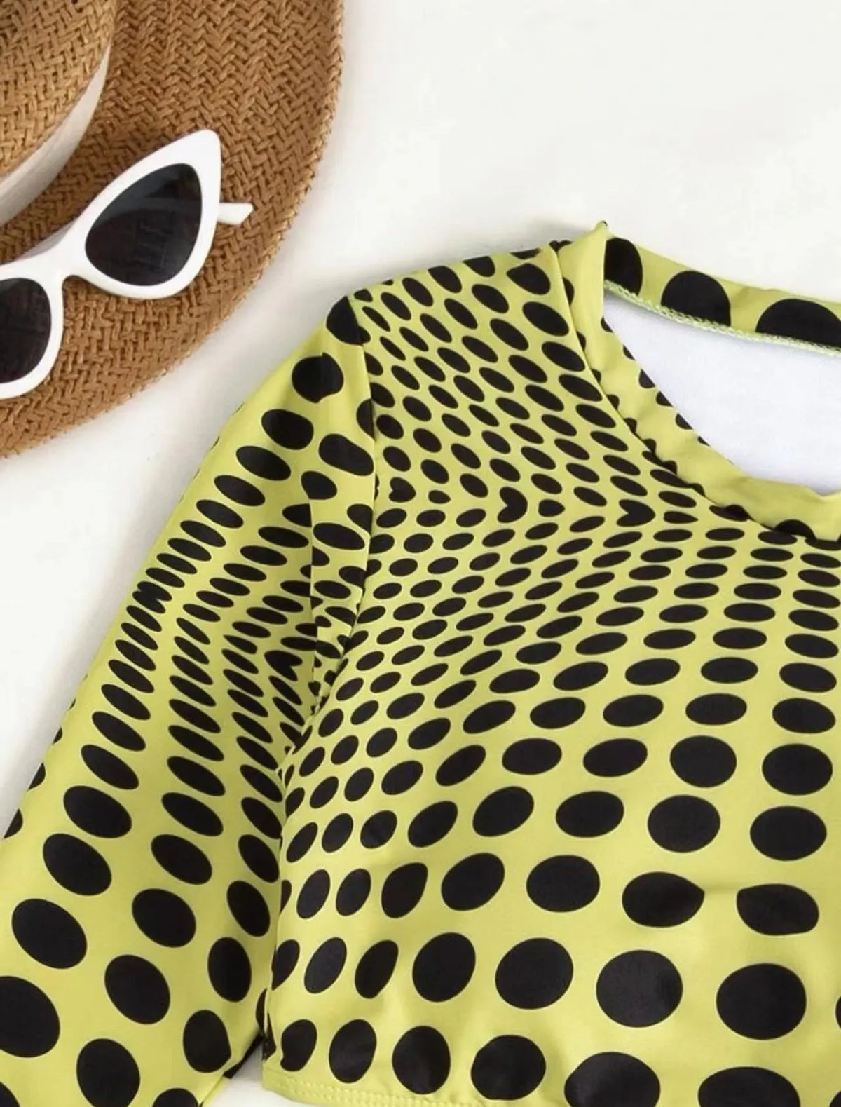 Women's green polka dot swimsuit three-piece set with bra, top and skirt on hanger