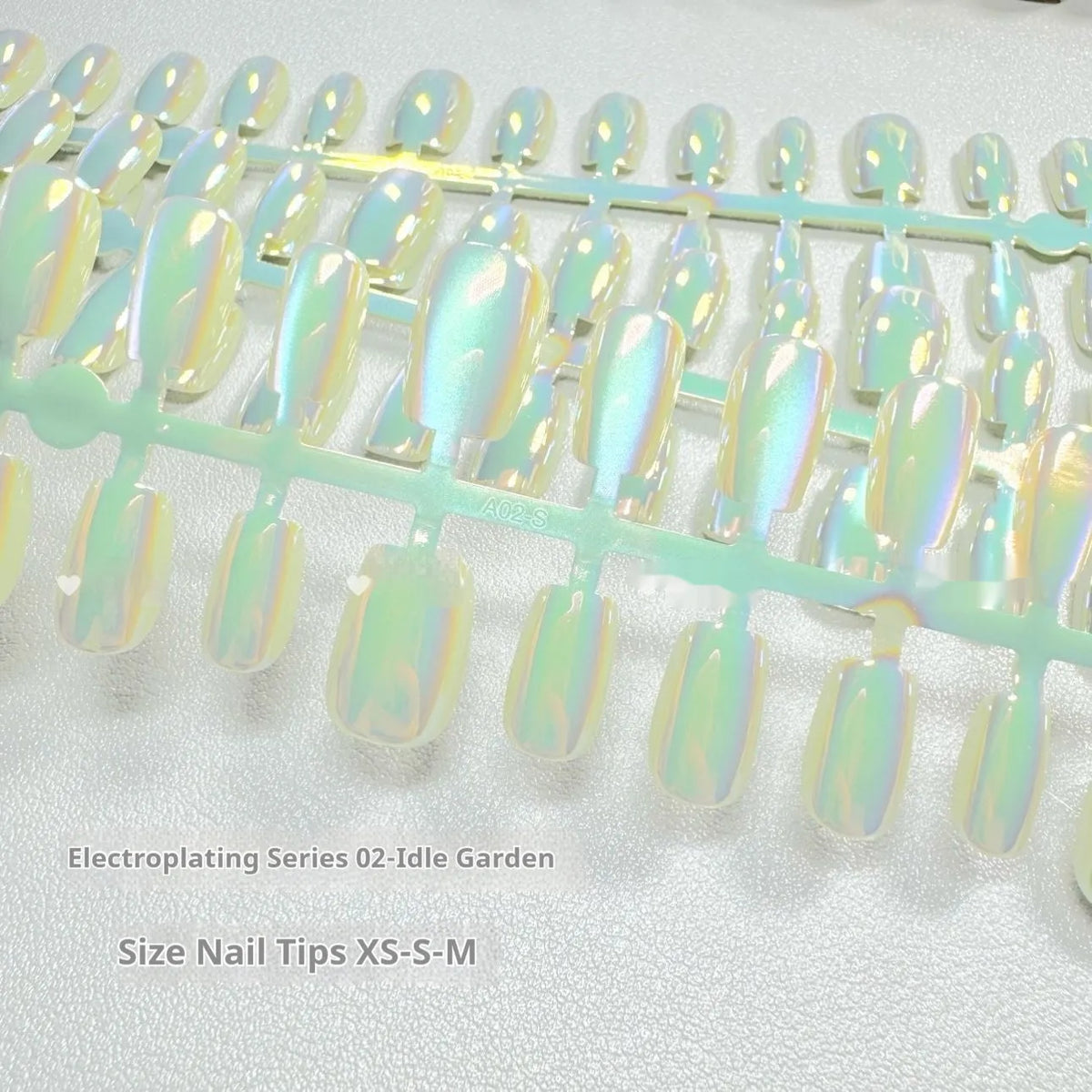 Electroplated Cat's Eye false nails showing Aurora light effect on short ladder shaped nails in XS, S, M sizes.