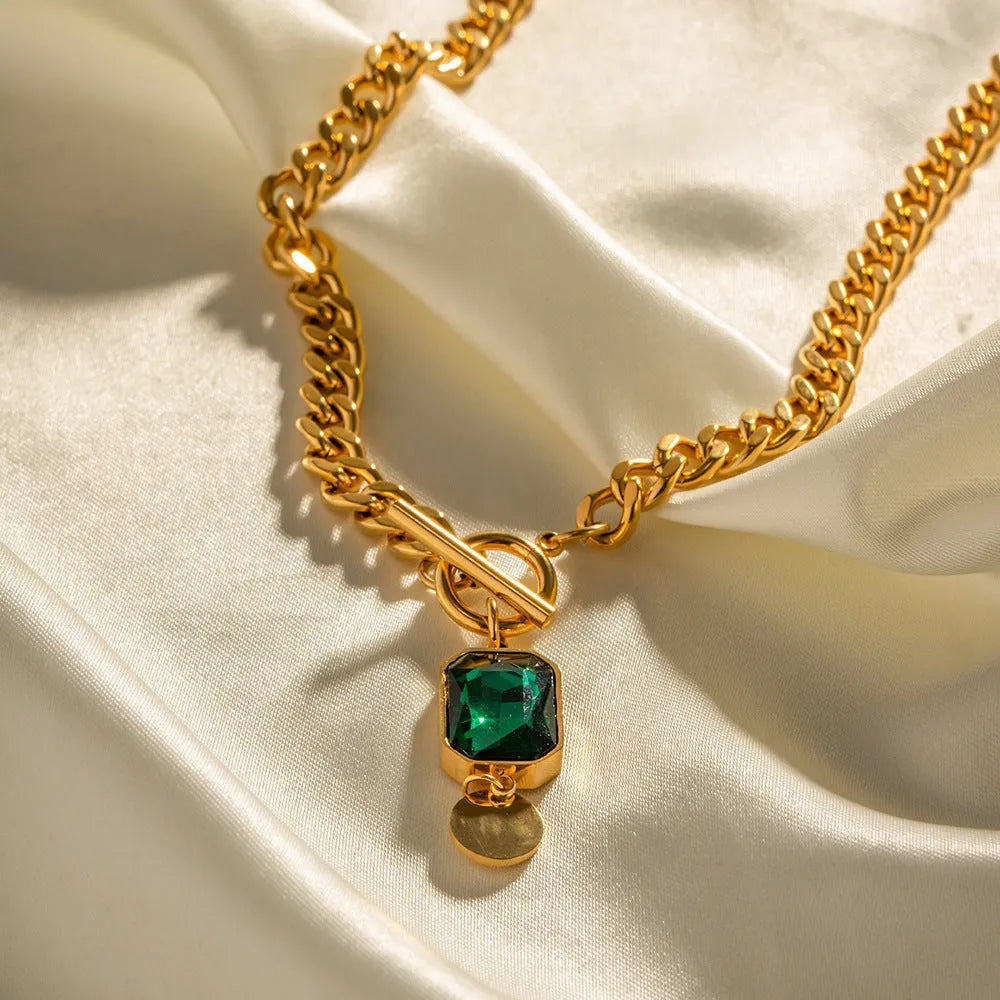 Gold tone geometric pendant necklace with emerald green zircon stone on Cuban link chain