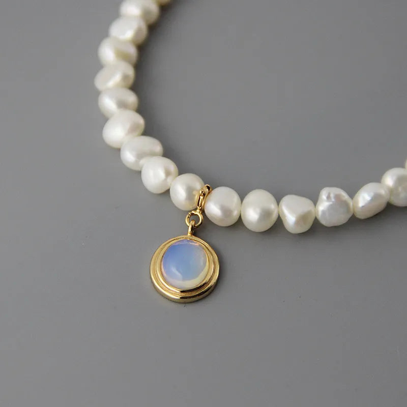 White geometric sterling silver pendant necklace with an irregular pearl on an adjustable chain.