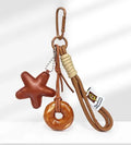 Brown soda bread handbag pendant with cartoon croissant design and carrying strap