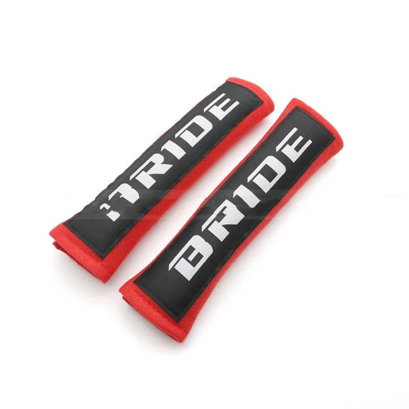 Pair of black cotton seatbelt shoulder pads with embroidery detail, showing dimensions