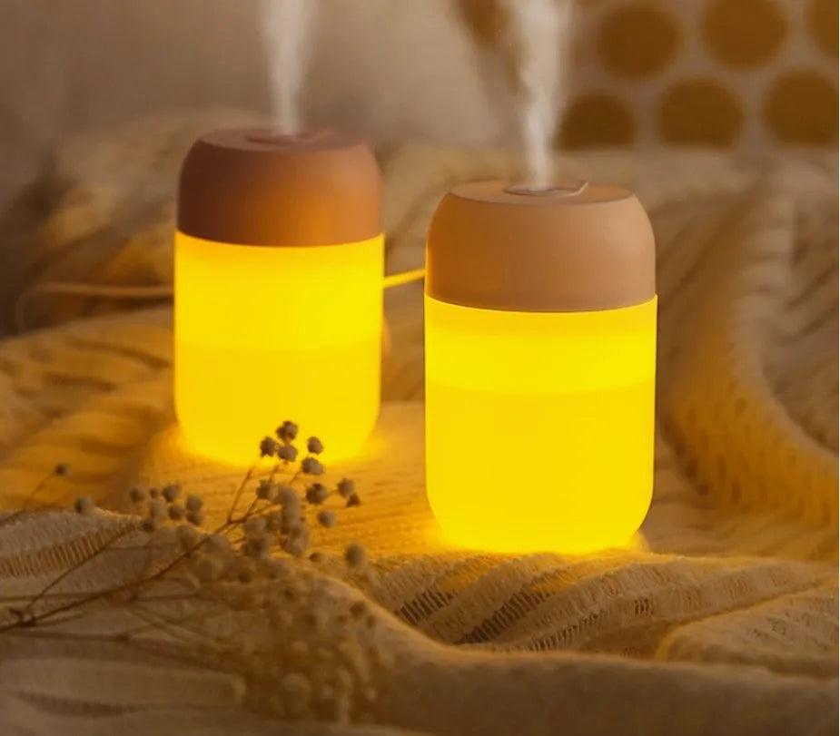 White cylindrical USB mini humidifier with charging cable on flat surface