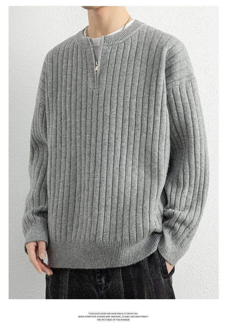 Man wearing a grey half zip loose fit textured knit sweater with long sleeves.