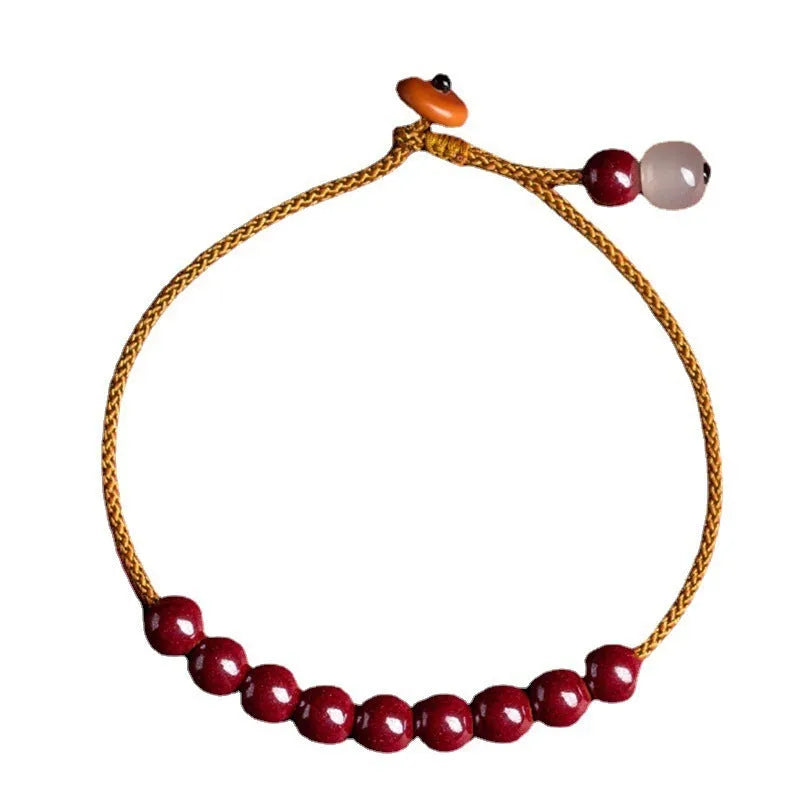Close-up of a red cinnabar and beige Hetian jade geometric bracelet with a hand-woven adjustable strap.