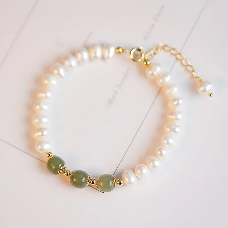 Diamond-shaped freshwater pearl bracelet in electroplated Hetian jade colour on a wrist.