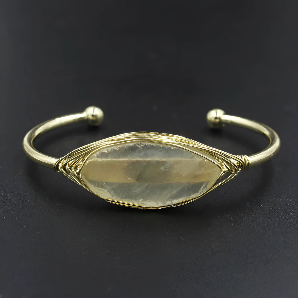 Natural raw gemstone bracelet in winding design on wrist, showing amorphous crystal stones and simple clasp.