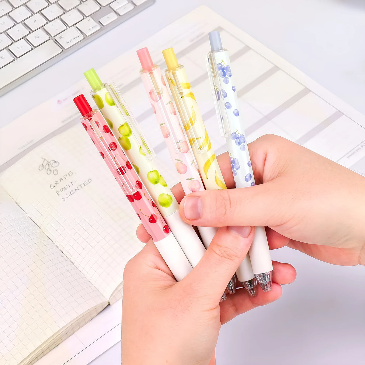 Three fruit scented 0.5mm black ink click pens with plastic barrels and replaceable refills