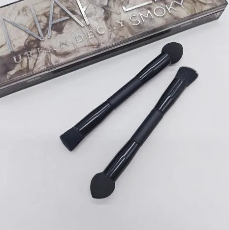 Elegant black double-headed makeup brush with miter sponge and angled concealer heads on a wooden handle.
