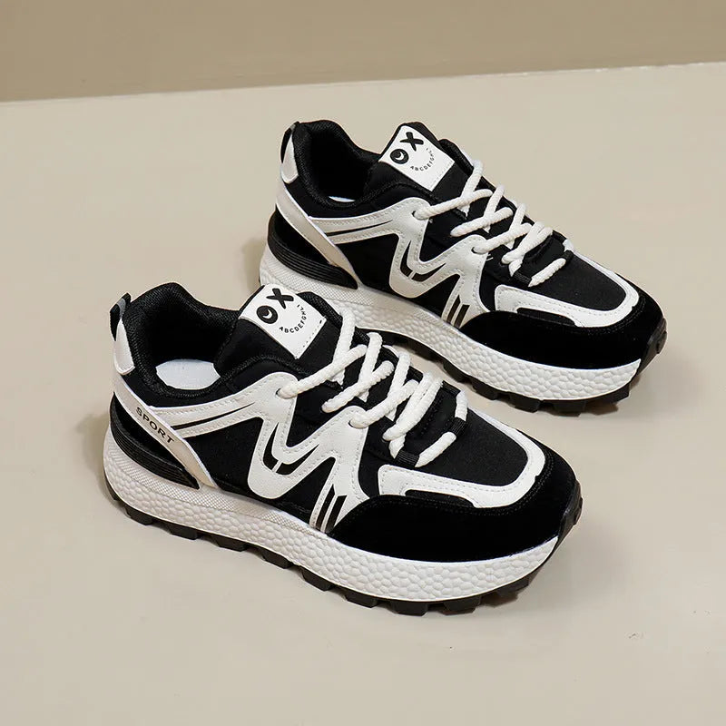 Women's black platform casual sports shoes with flat heel and white lace-up front closure on a neutral background.