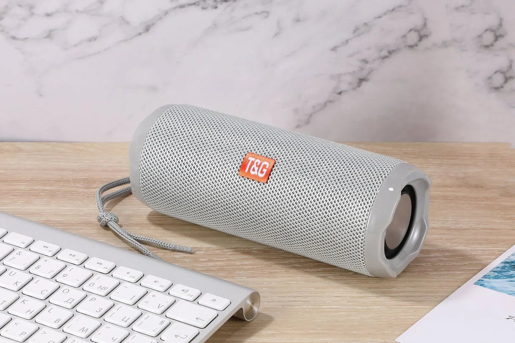 Fabric-covered portable wireless Bluetooth speaker with a card holder, shown in multiple colour options.