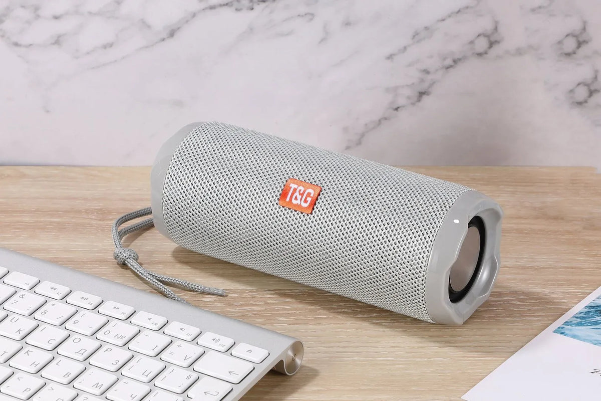 Fabric-covered portable wireless Bluetooth speaker with a card holder, shown in multiple colour options.