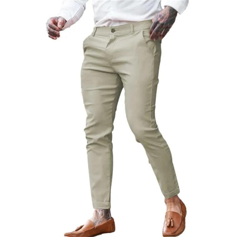 Men's slim pencil trousers in stretch cotton twill fabric on a hanger, showing the mid waist and slim leg cut.